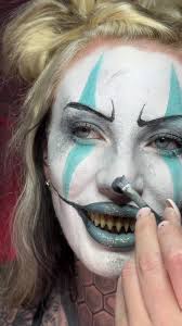 A Juggalo fan showcasing intricate clown face paint for a TikTok video.