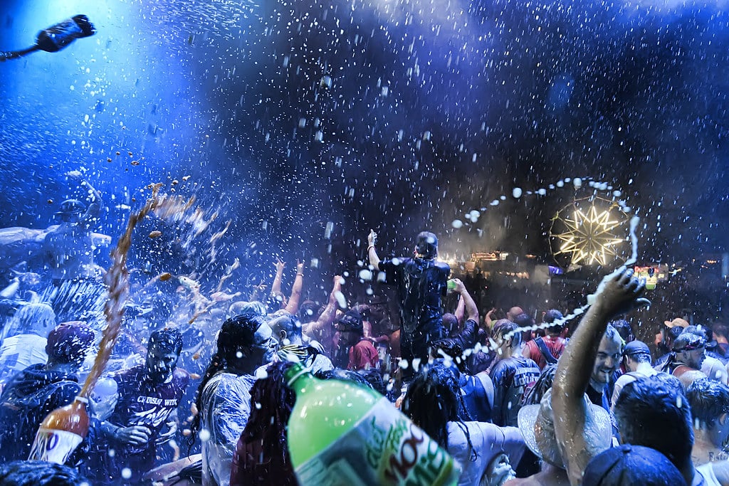 Insane Clown Posse fans on stage during Faygo Armageddon, spraying Faygo soda in a high-energy performance.